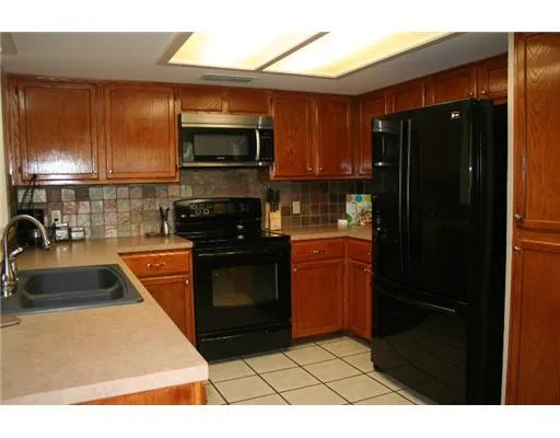 a kitchen with granite countertop a refrigerator and a sink