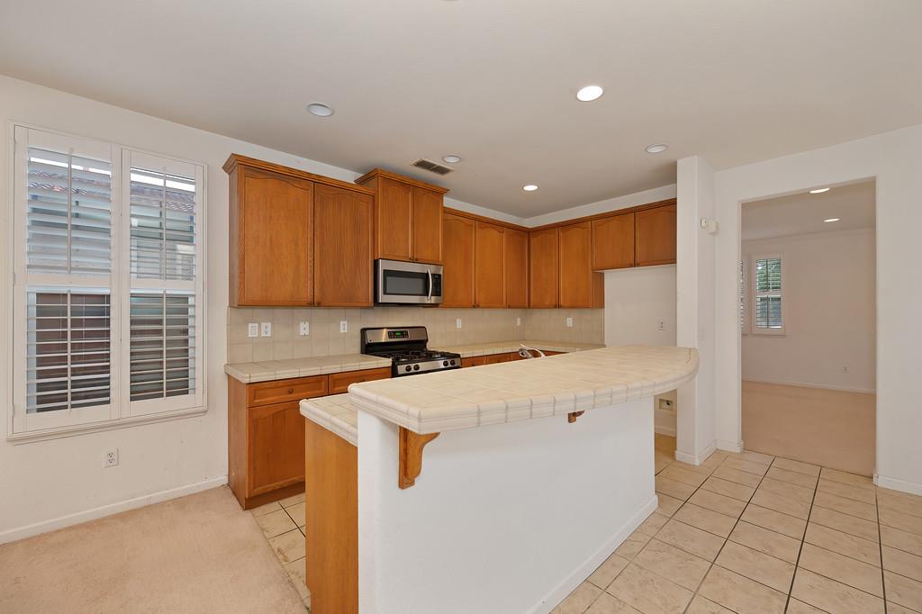 3505 Husch Way Rancho Cordova, CA 95670 - Photo 13 of 37 a kitchen with stainless steel appliances a stove a refrigerator a sink and white cabinets