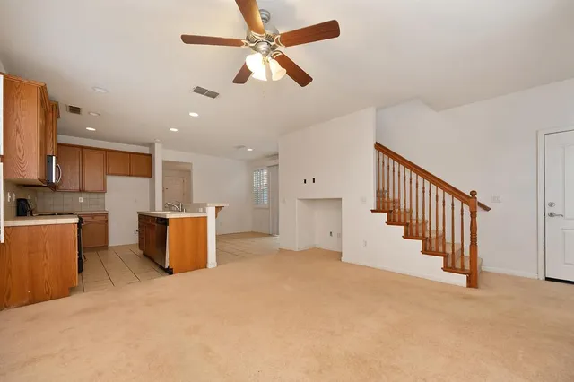 a view of empty room with wooden floor and ceiling fan