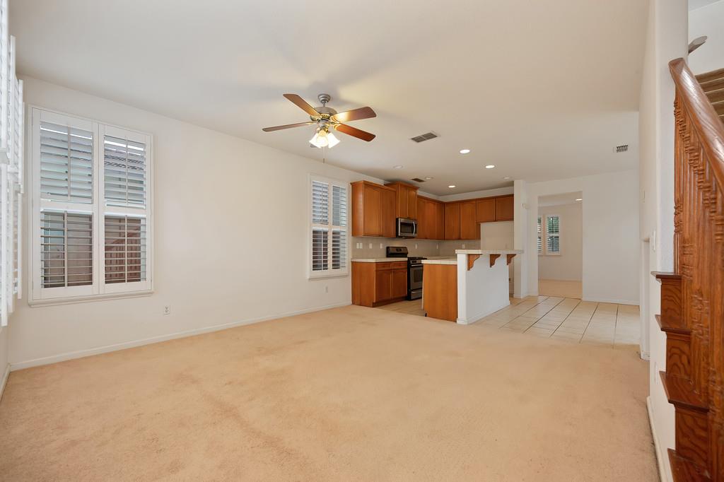 3505 Husch Way Rancho Cordova, CA 95670 - Photo 17 of 37 a large white kitchen with stainless steel appliances granite countertop a stove top oven a sink dishwasher and a refrigerator with wooden floor