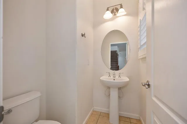 a bathroom with a sink mirror and toilet