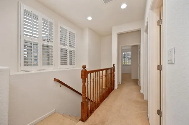 a view of a hallway with windows and stairs