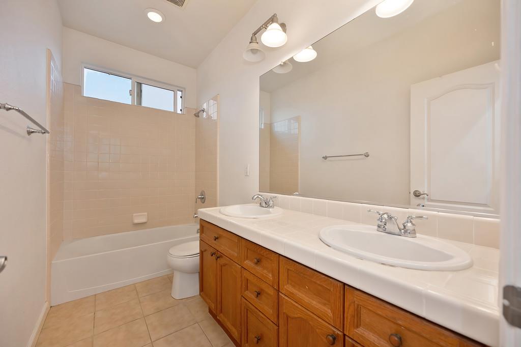3505 Husch Way Rancho Cordova, CA 95670 - Photo 24 of 37 a bathroom with a granite countertop sink a toilet and shower