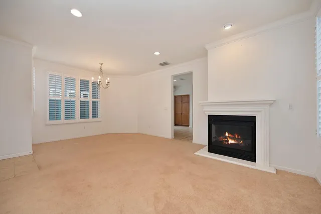 a view of an empty room with a fireplace and a window