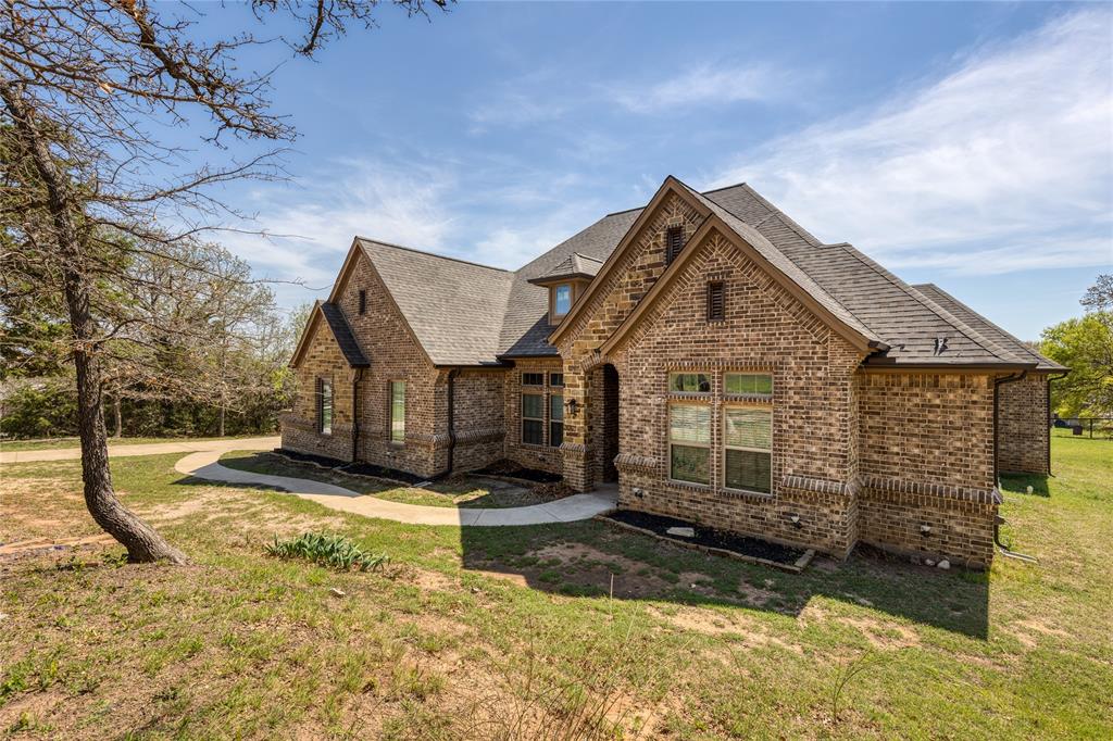 Front of home featuring stone & brick siding and a front lawn