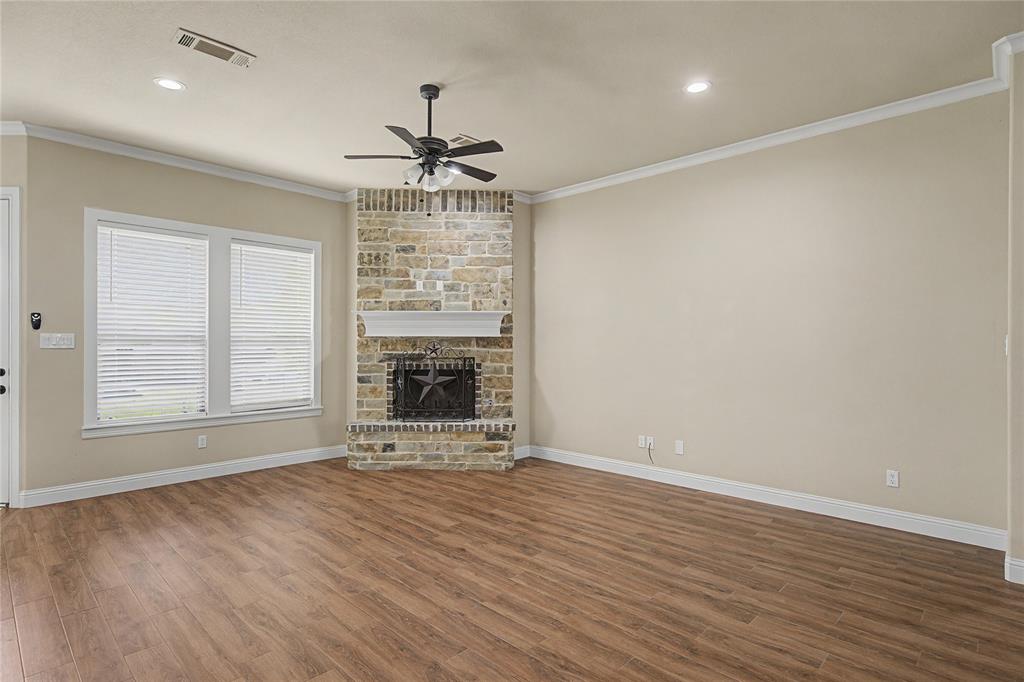 143 Wrigley Drive Springtown, TX 76082 - Photo 13 of 38 Lovely corner WBFP, living room with crown molding, wood-style flooring, a ceiling fan, a stone fireplace, and recessed lighting