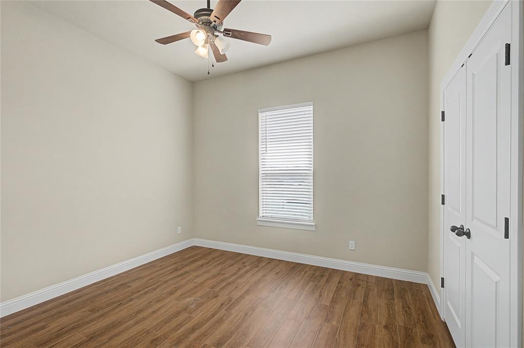 143 Wrigley Drive Springtown, TX 76082 - Photo 30 of 38 an empty room with wooden floor fan and windows