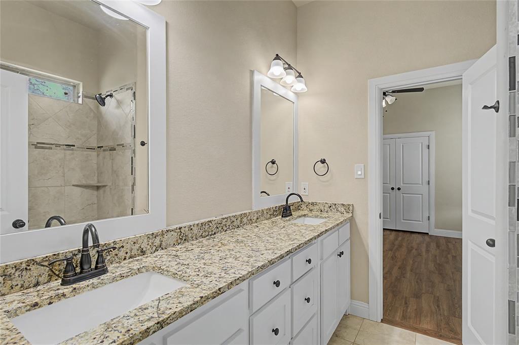 143 Wrigley Drive Springtown, TX 76082 - Photo 31 of 38 a bathroom with a granite countertop double vanity sink and mirror