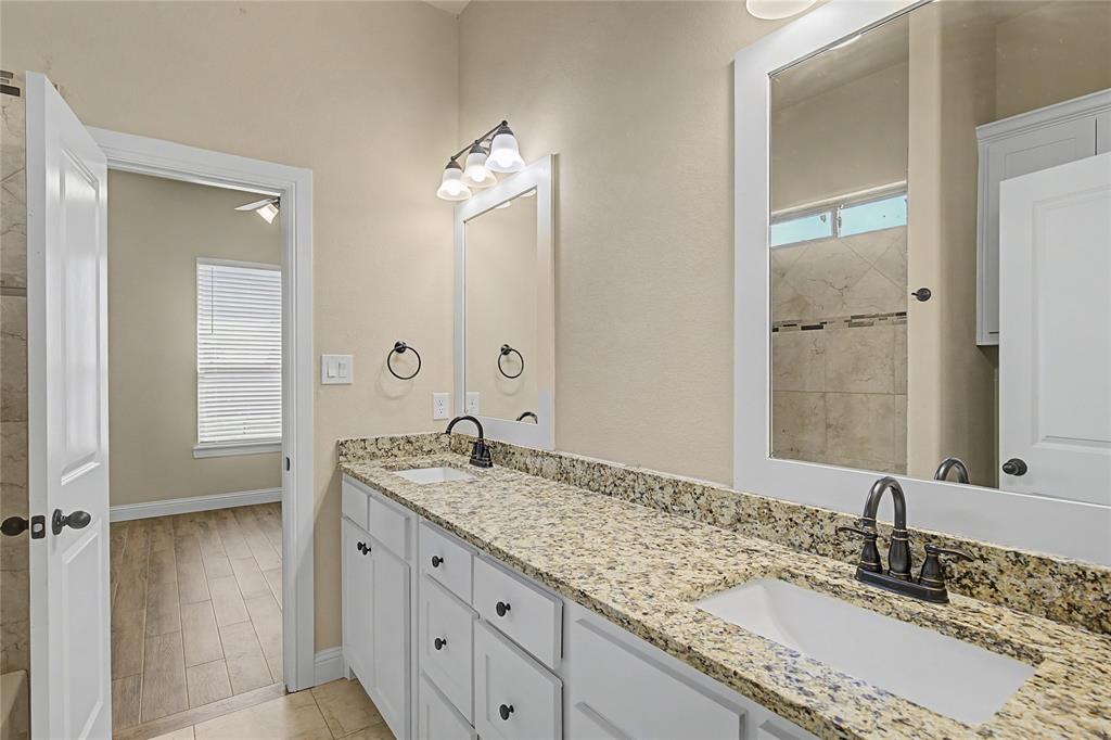 143 Wrigley Drive Springtown, TX 76082 - Photo 32 of 38 a bathroom with a granite countertop sink double and mirror