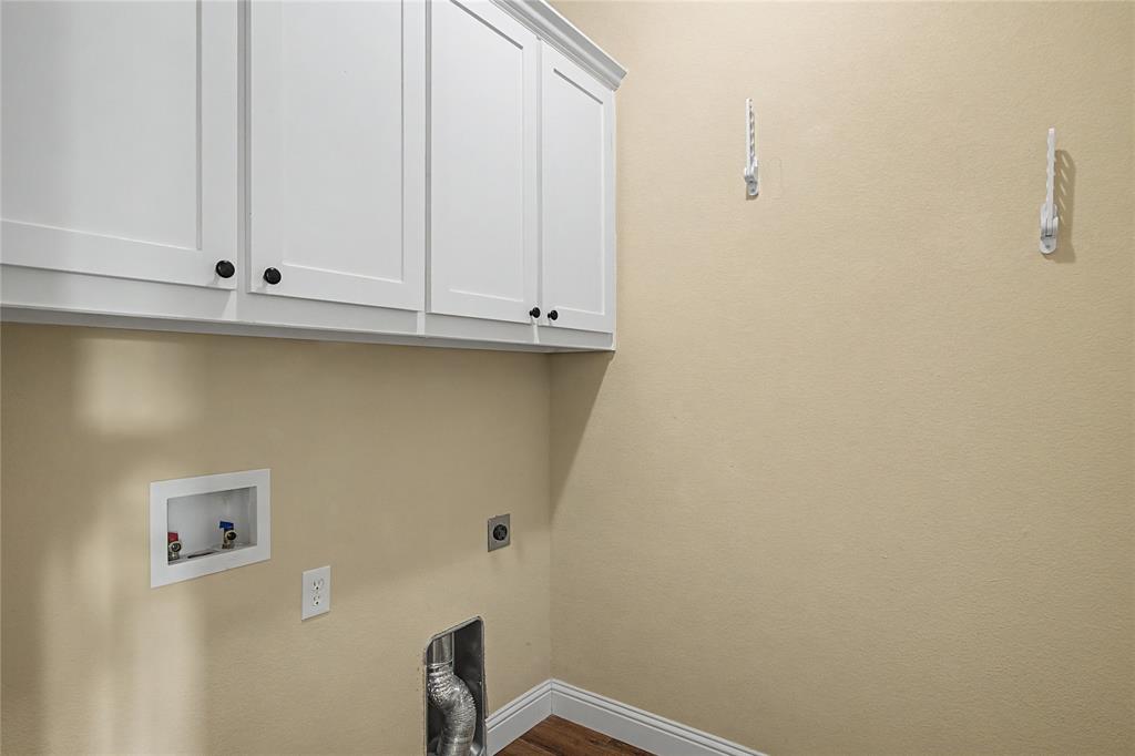 143 Wrigley Drive Springtown, TX 76082 - Photo 33 of 38 Laundry room featuring hookup, white cabinetry.