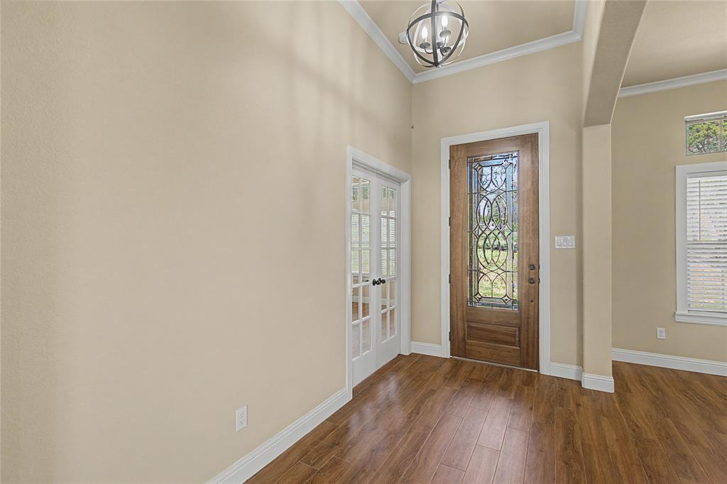 143 Wrigley Drive Springtown, TX 76082 - Photo 6 of 38 Entryway featuring crown molding, wood-style flooring, and a chandelier