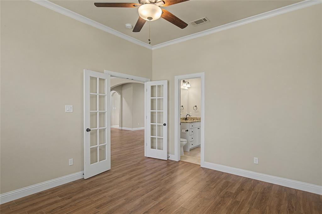 143 Wrigley Drive Springtown, TX 76082 - Photo 7 of 38 Front study or guest bedroom with french doors, wood like tiled finished floors, crown molding, a ceiling fan, and ensuite bathroom that connects to adjacent hallway