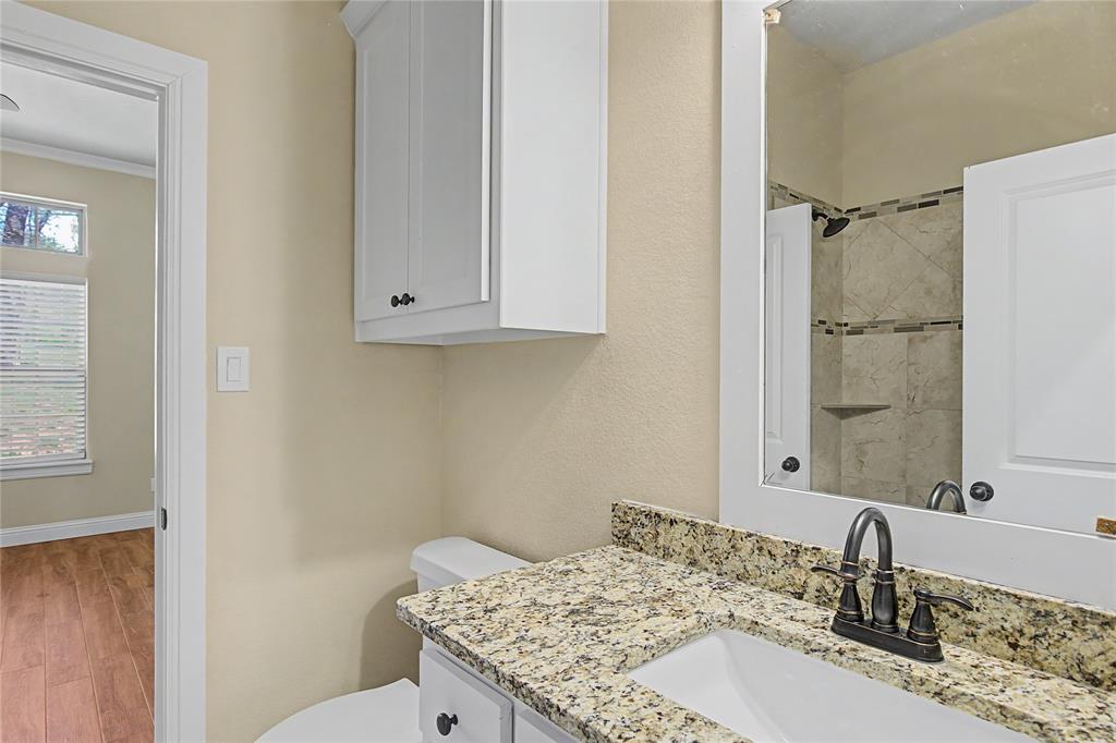 143 Wrigley Drive Springtown, TX 76082 - Photo 8 of 38 a bathroom with a granite countertop sink toilet and shower