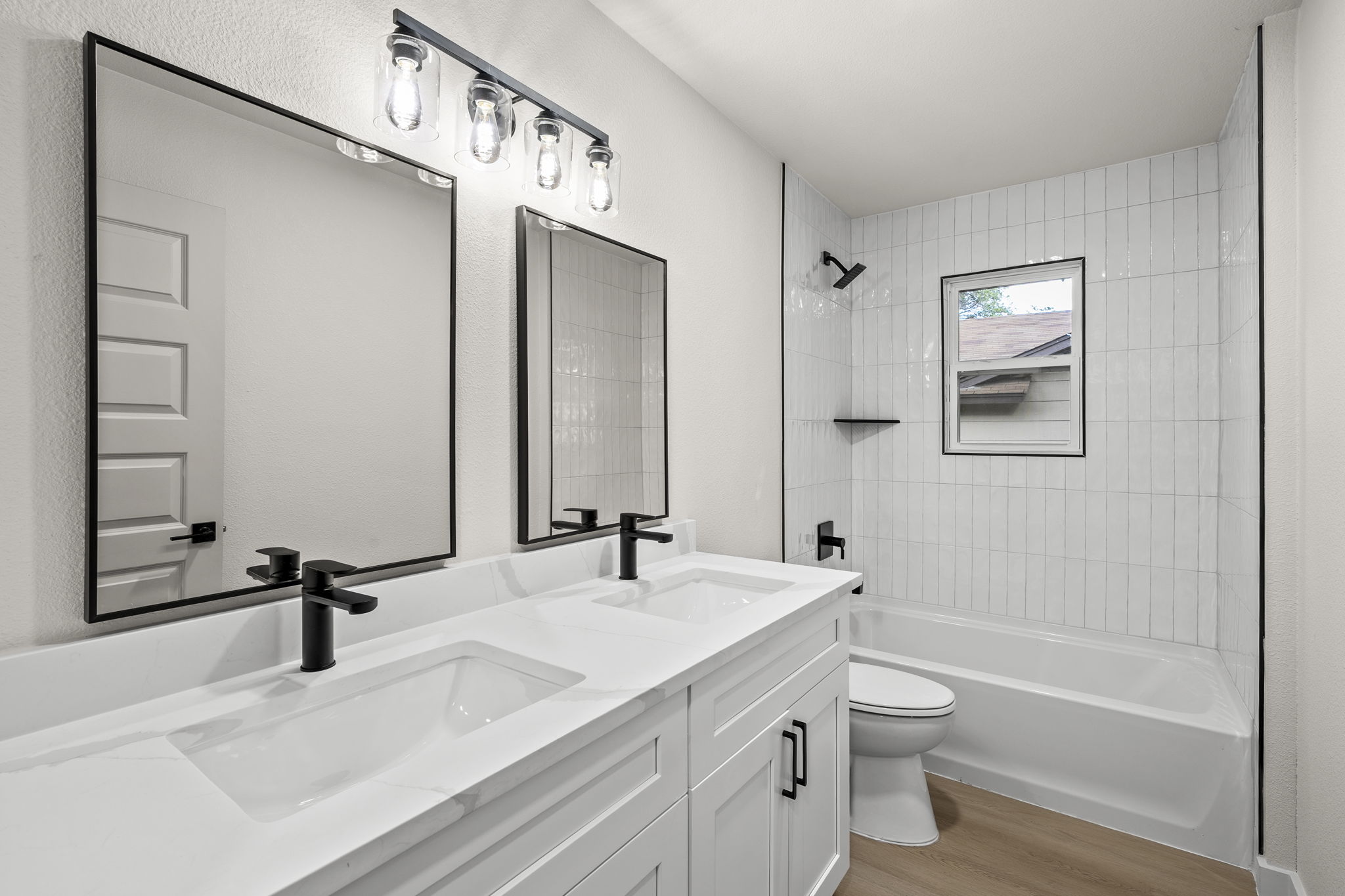 2107 Cindy Lane Austin, TX 78727 - Photo 23 of 33 Contemporary bathroom featuring a dual vanity with white quartz countertops, matte black faucets, and rectangular framed mirrors