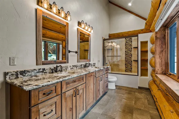 a bathroom with a granite countertop sink and a large mirror