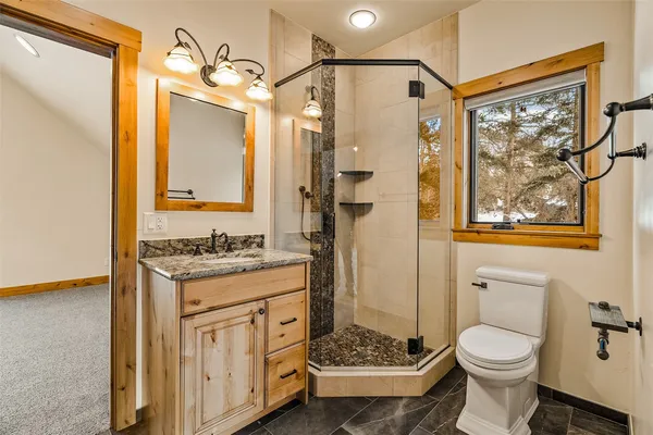 a bathroom with a granite countertop sink toilet and shower