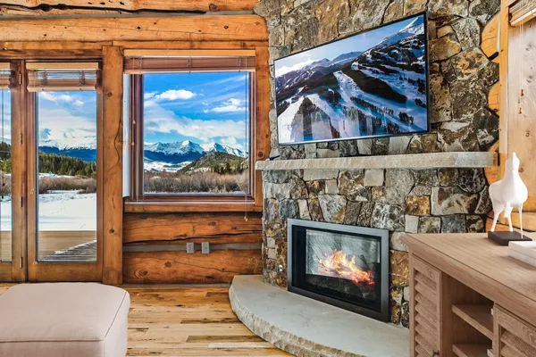 a living room with a fireplace and a floor to ceiling window