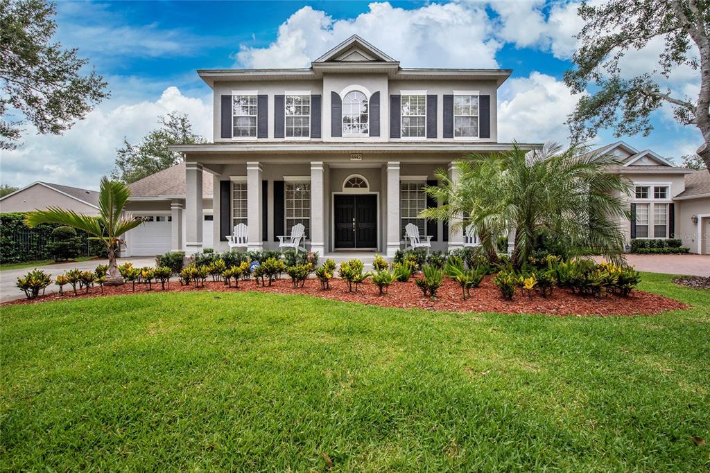a front view of a residential houses with yard and green space