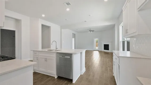 a large kitchen with stainless steel appliances a large counter top a stove and a refrigerator