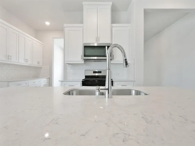 a kitchen with granite countertop a sink and a stove top oven
