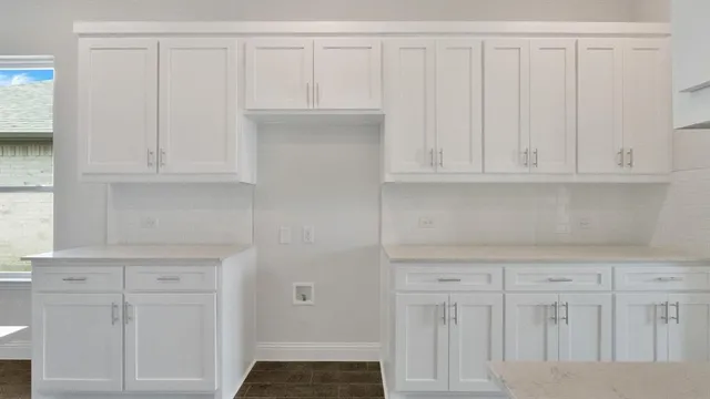 a kitchen with white cabinets and white appliances