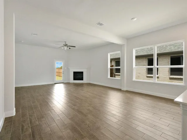 a view of a livingroom with wooden floor and a fireplace