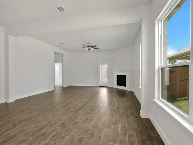 a view of a livingroom with wooden floor and a window