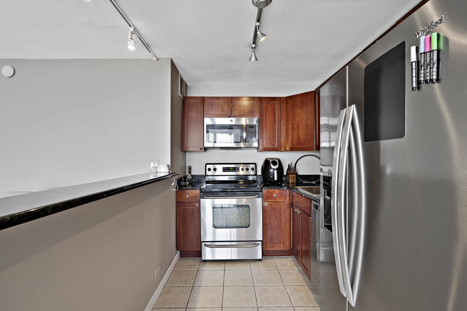 655 West Irving Park Road, Unit 4108 Chicago, IL 60613 - Photo 9 of 32 a kitchen with stainless steel appliances granite countertop a refrigerator and a stove top oven