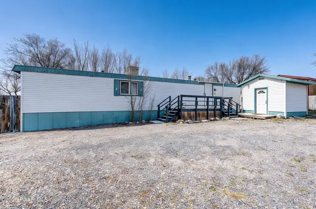 a view of a house with a yard and large tree