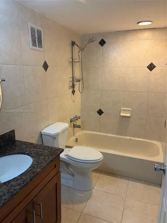 a bathroom with a granite countertop toilet a sink and bathtub