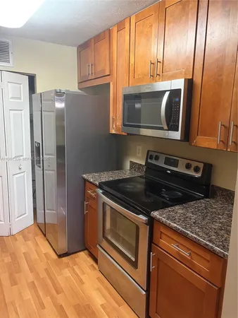a kitchen with granite countertop stainless steel appliances and wooden cabinets
