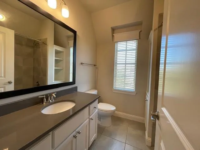 a bathroom with a granite countertop sink toilet a mirror and a tub