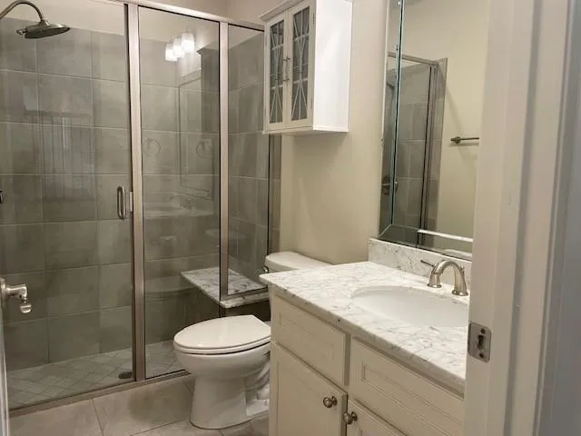 a bathroom with a granite countertop sink toilet and shower