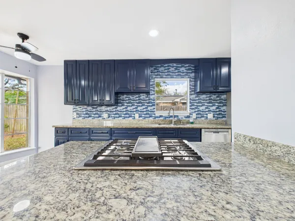 a kitchen with a stove a sink and a counter space