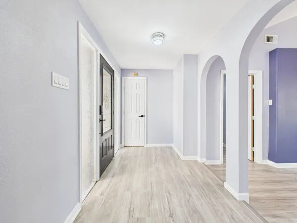 a view of a room with wooden floor and entryway