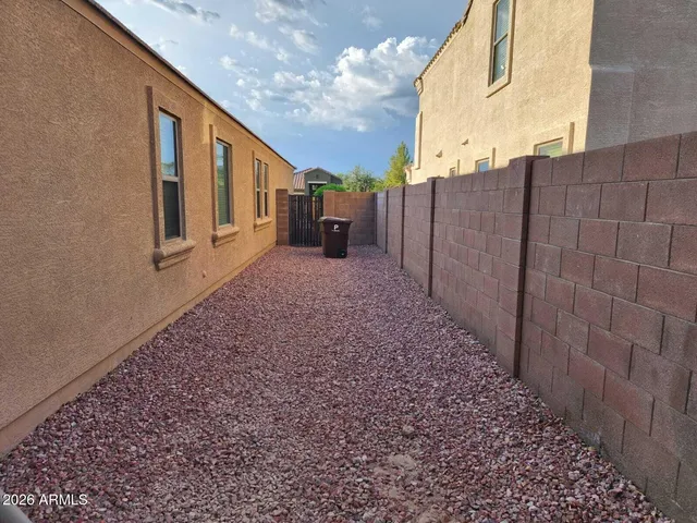a view of a house with backyard and wooden fence