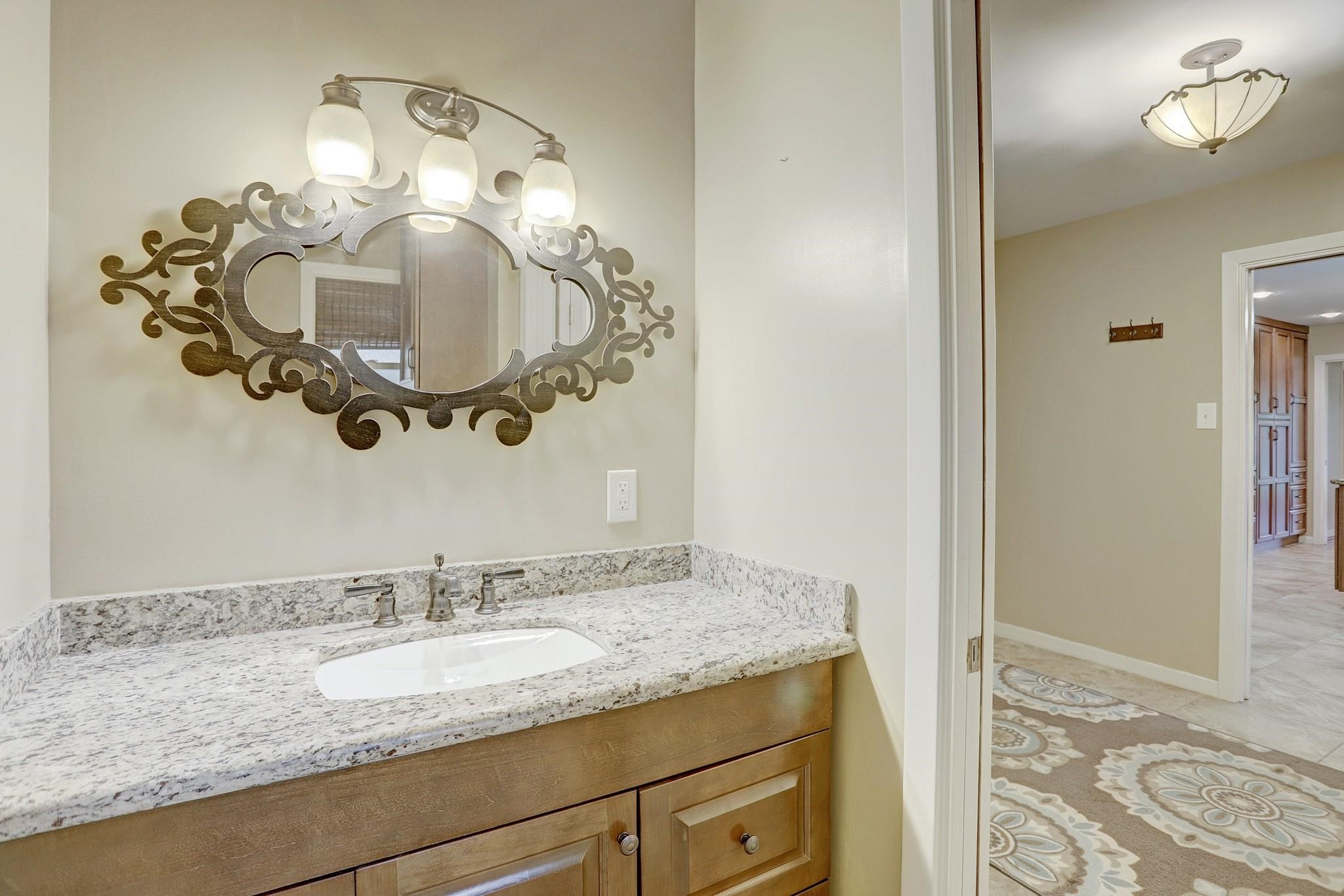 8019 Colgate Street Houston, TX 77061 - Photo 14 of 27 Gorgeous half bath with granite counters and wood custom cabinetry.