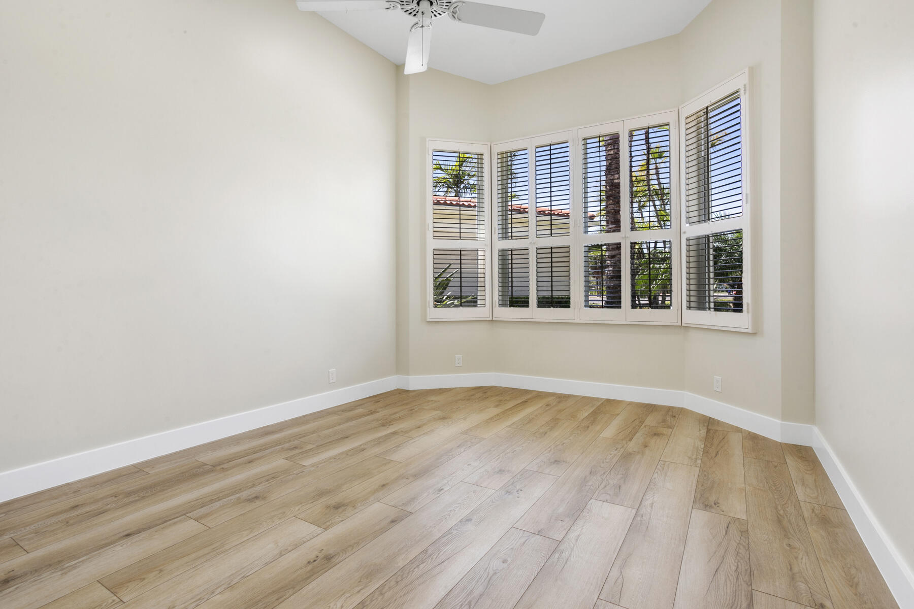15810 Windrift Drive Jupiter, FL 33477 - Photo 32 of 52 an empty room with wooden floor and windows