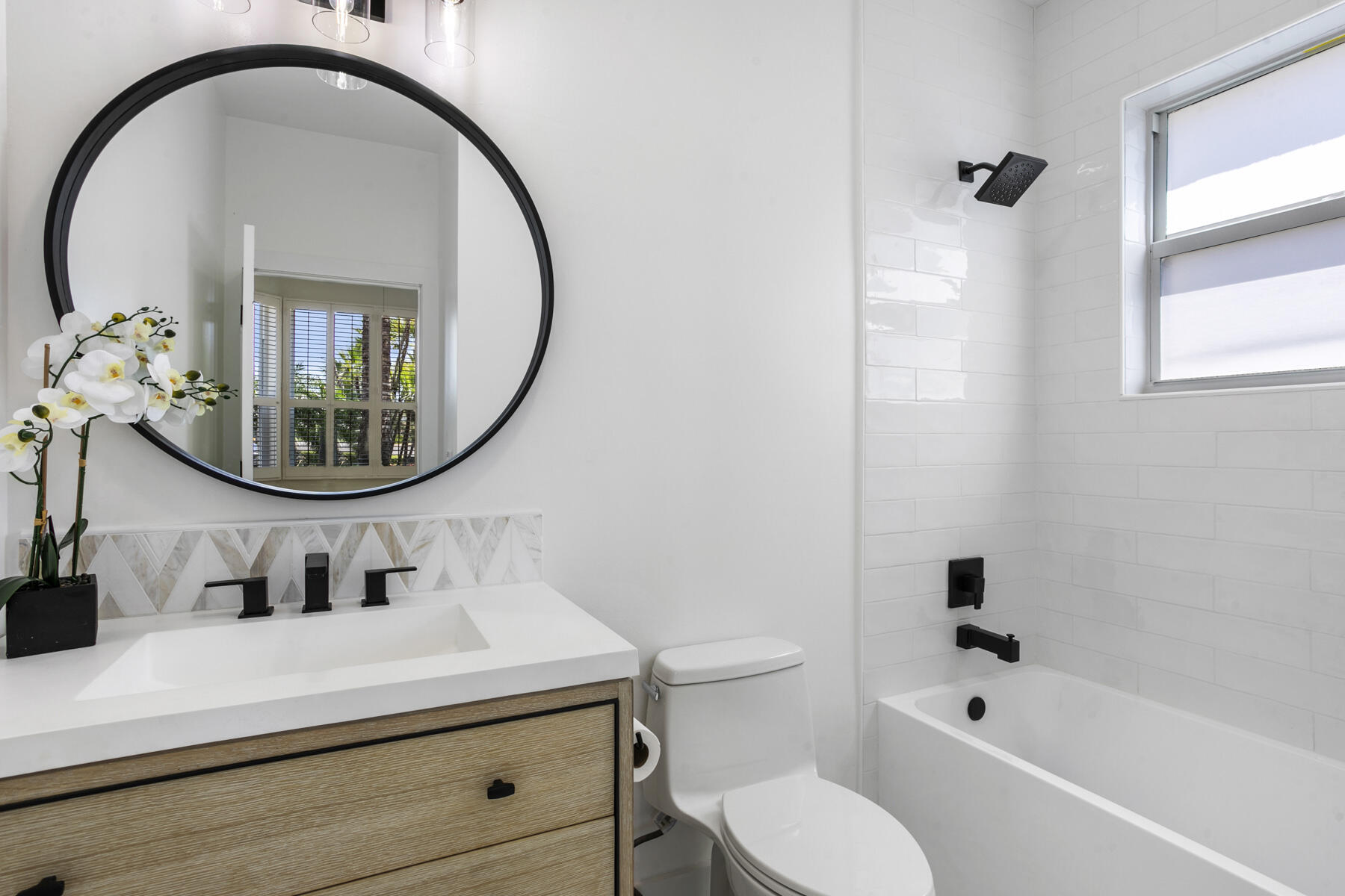 15810 Windrift Drive Jupiter, FL 33477 - Photo 33 of 52 a bathroom with a sink a mirror a toilet and a bathtub