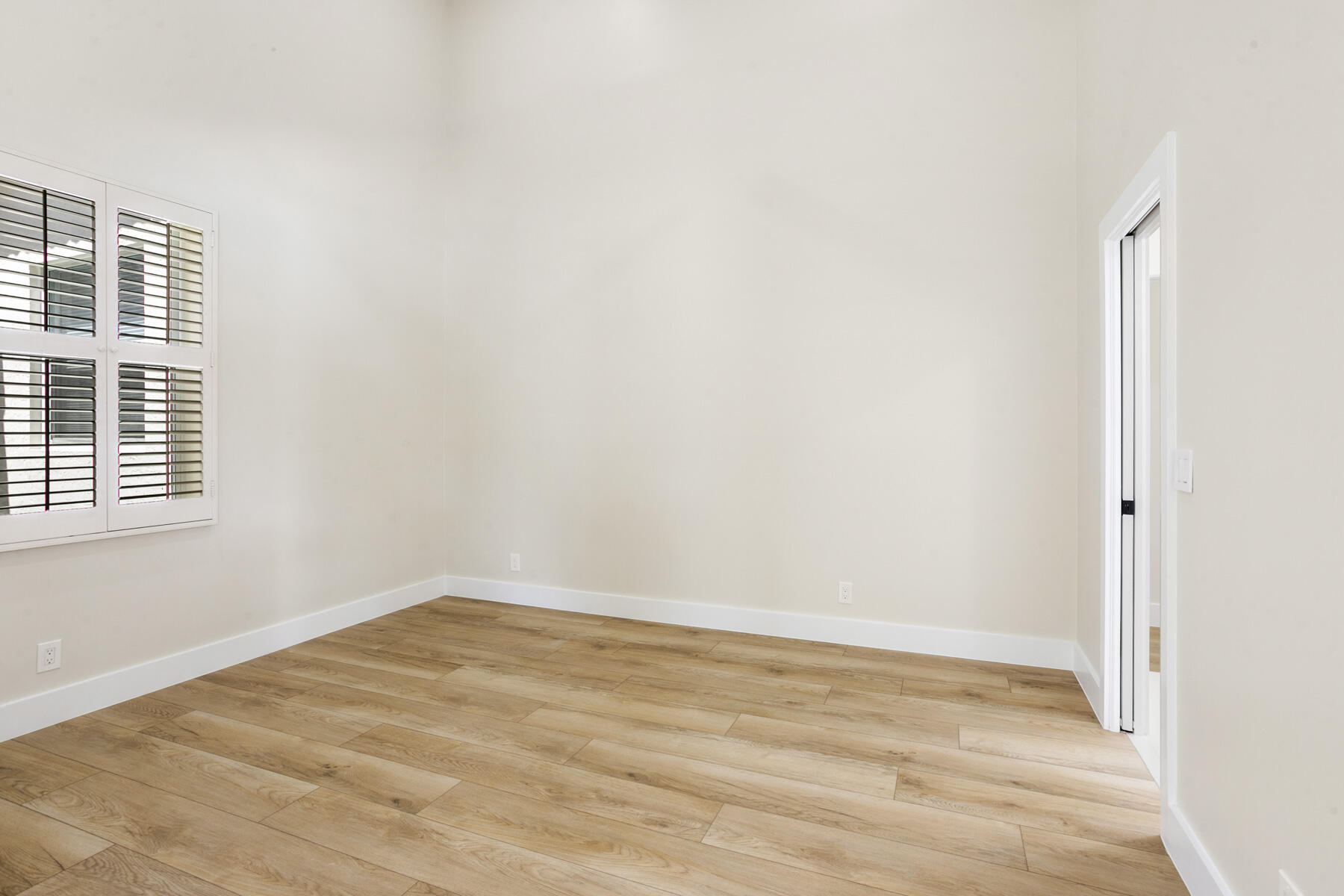 15810 Windrift Drive Jupiter, FL 33477 - Photo 35 of 52 a view of an empty room with wooden floor and a window