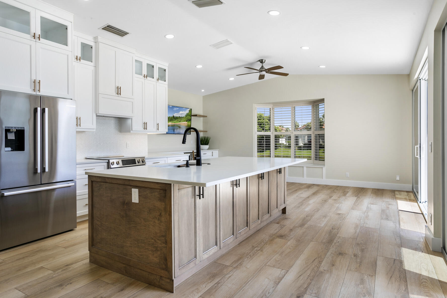 15810 Windrift Drive Jupiter, FL 33477 - Photo 10 of 52 a kitchen with stainless steel appliances a sink stove refrigerator and cabinets