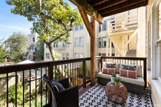 a balcony with wooden floor and outdoor seating