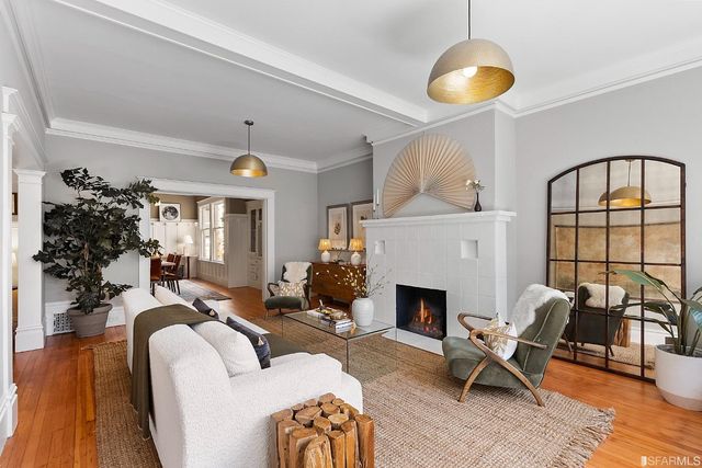 a living room with furniture a chandelier and a fireplace