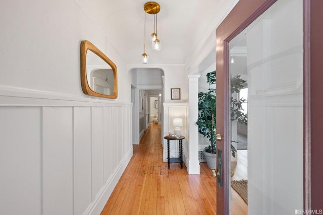 a view of a hallway with wooden floor and staircase