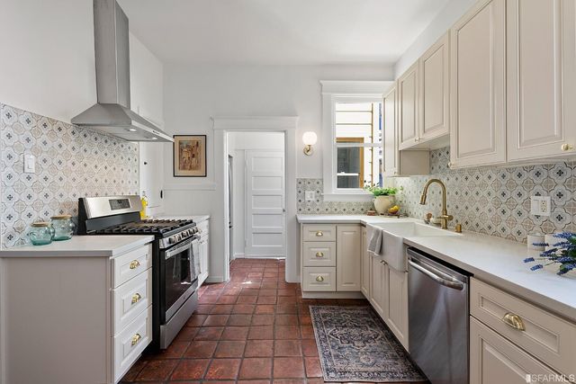 a kitchen with stainless steel appliances a stove sink and cabinets