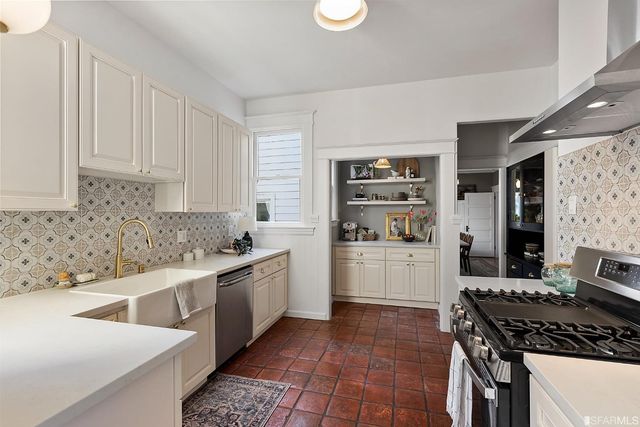 a kitchen with stainless steel appliances a stove a sink and a refrigerator
