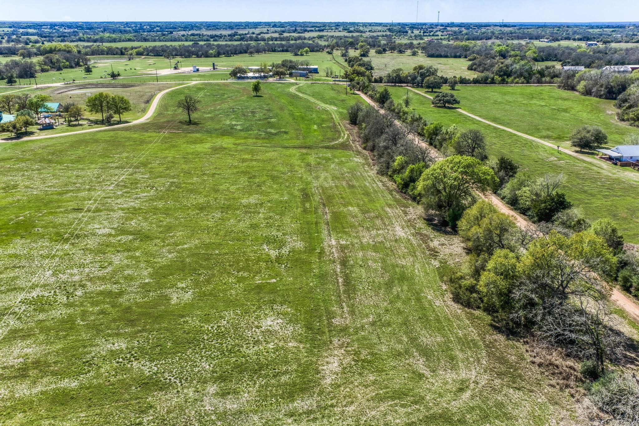 11646 Schuster Road Round Top, TX 78954 - Photo 3 of 8 a view of a green field with lawn chairs