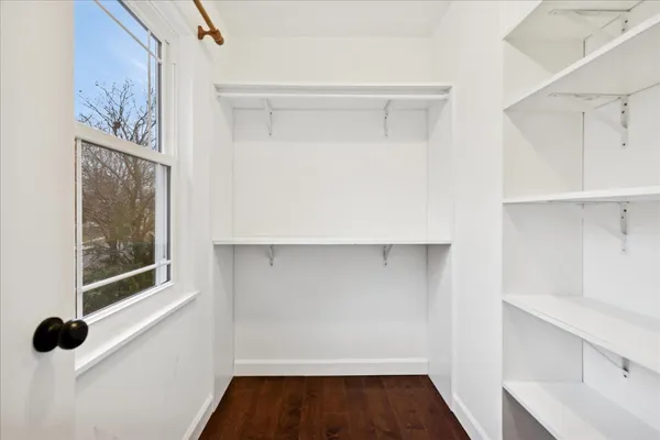 a view of walk in closet with clothes and shoes