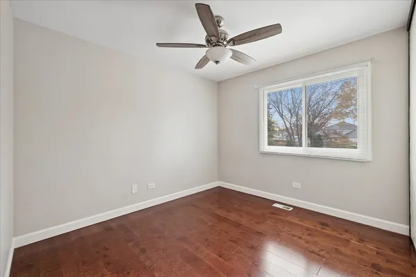 a view of a big room with wooden floor and windows