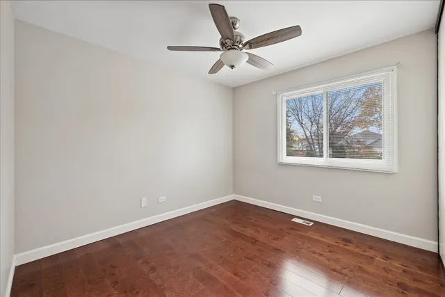 a view of a big room with wooden floor and windows